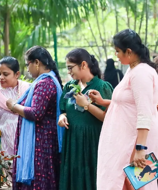 A day with nature for our Montessori Preprimary adult learners. This image from a nature walk in Richard's Park, Bangalore, shows participants engaging in hands-on exploration of flora and fauna, learning to observe and connect with the environment just as a child does.