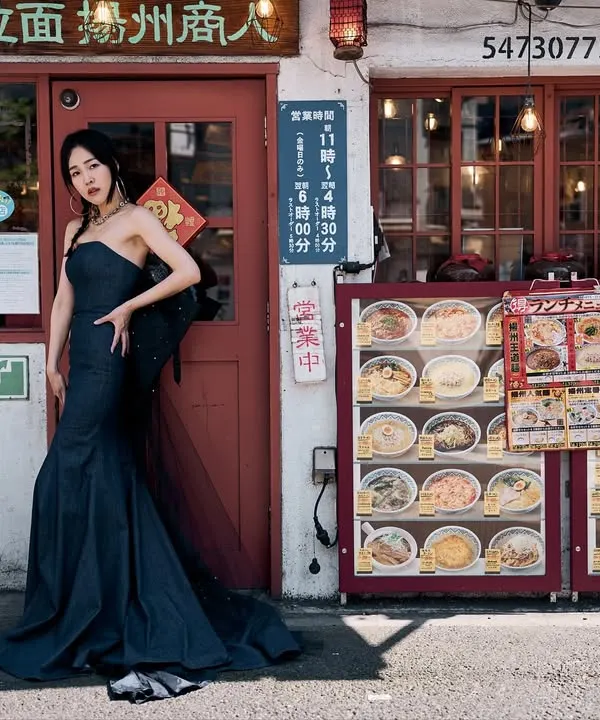 Shooting in front of a ramen shop in Japan. I love the contrast between the high-fashion gown and the everyday street scene. The lines and colors of the location create a perfect frame.