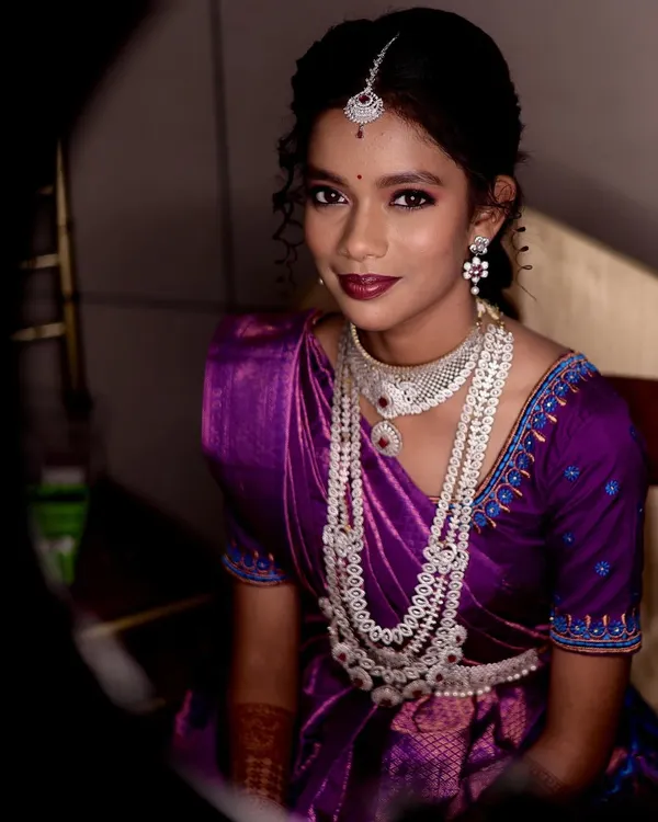 A dramatic bridal portrait using creative lighting. The bride is dressed in a purple Langa Voni with beautiful silver jewelry, creating a striking and memorable image.