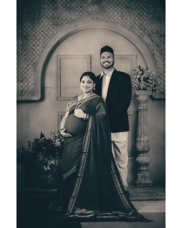A regal maternity portrait celebrating heritage and the creation of a new family legacy. This studio session uses a vintage Maharashtrian theme, with traditional attire and classic monochrome toning to create a powerful, timeless piece of art.