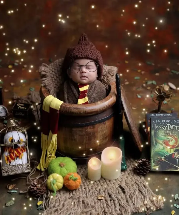 Our full Harry Potter set, complete with a wizard's trunk, Hedwig in a cage, and magical lighting. This wide shot shows the level of detail we put into our themed newborn photography.