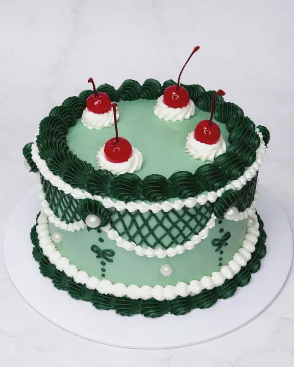 Lambeth cakes are the best, aren't they? And I do them the best too. This green vintage cake with dark green lattice piping and cherries is Instagram-perfect and tastes divine.