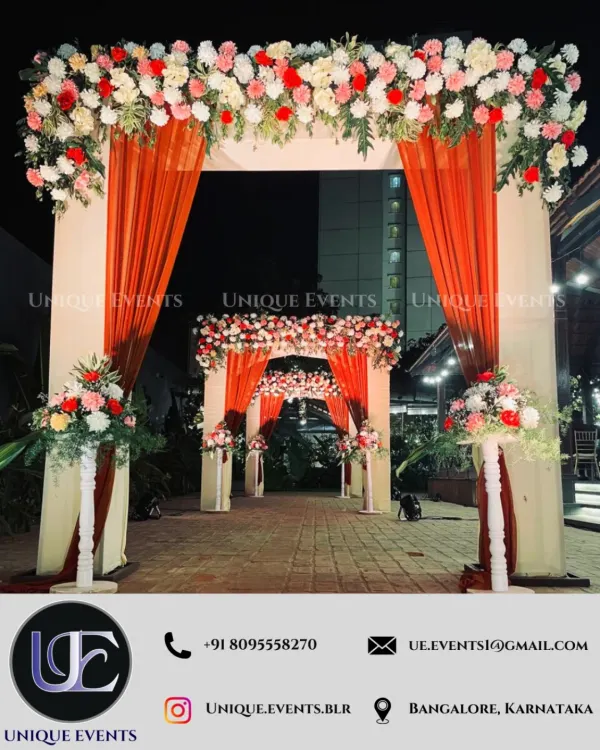 I believe in making a grand first impression. This luxurious entrance, featuring a towering arch with lush floral arrangements and elegant orange drapery, sets a spectacular tone for a housewarming party or wedding reception.