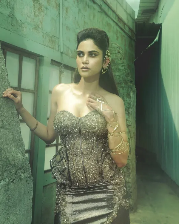 A powerful editorial look for Aaditi Pohankar. The makeup is strong and sculpted, with a metallic sheen on the skin that complements the structured corset and edgy styling. The face card never declines.