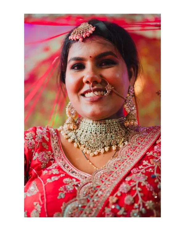 A close-up portrait of a radiant bride, her genuine smile and beautiful jewelry captured in stunning detail. This is a perfect example of a classic, happy bridal shot.