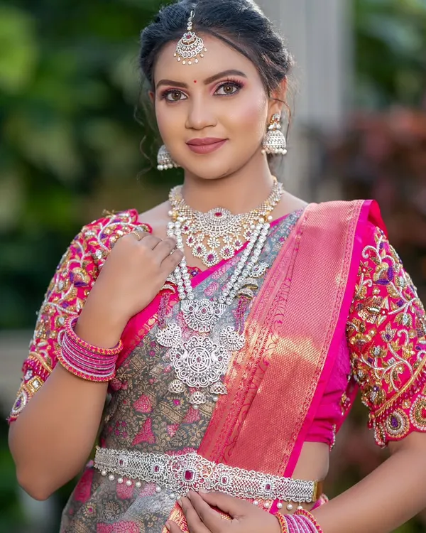 This bride is wearing a stunning silver-finish necklace with pearl detailing. It's a modern design that is perfect for a reception.