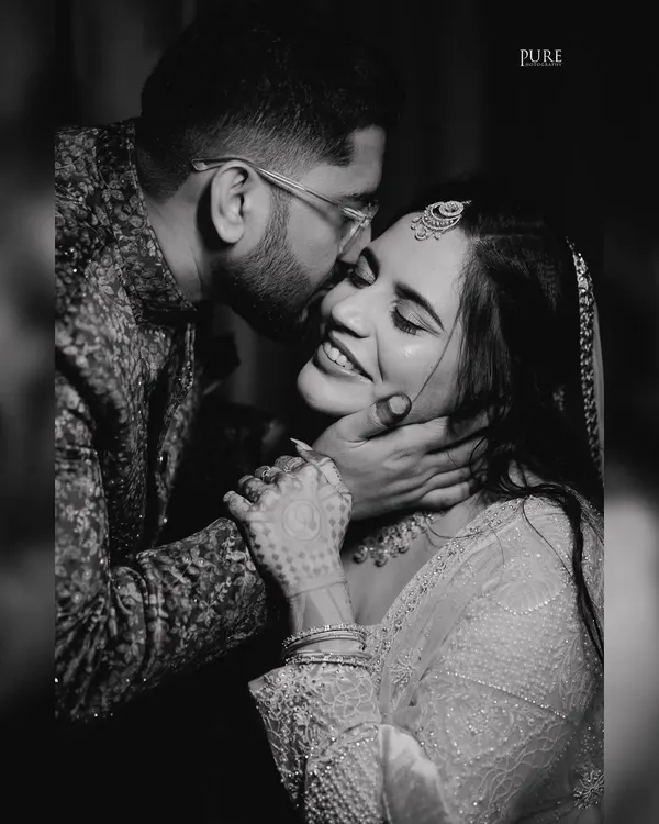 A beautiful black and white close-up of Aditya kissing Jini's forehead during their engagement session. This timeless photo focuses purely on the emotion and connection between the couple.