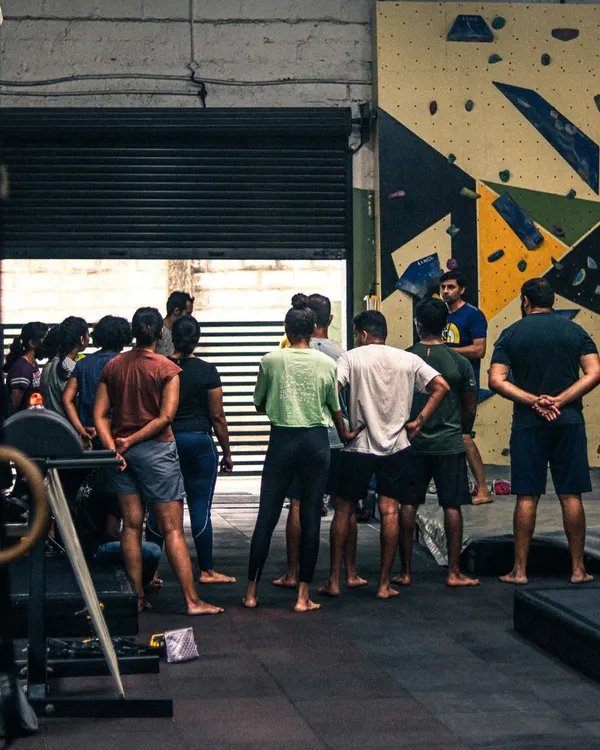 Every workshop starts with a briefing from our experienced instructors. Here, a group of new climbers learns about the day's goals and basic safety before hitting the walls.