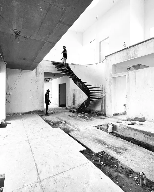 The raw form of a helical staircase in a private residence in Tiruppur. Designed to be a sculptural element in the main hall, the 'missing shaft' creates a sense of lightness and dynamism, with a skylight above illuminating the entire structure.
