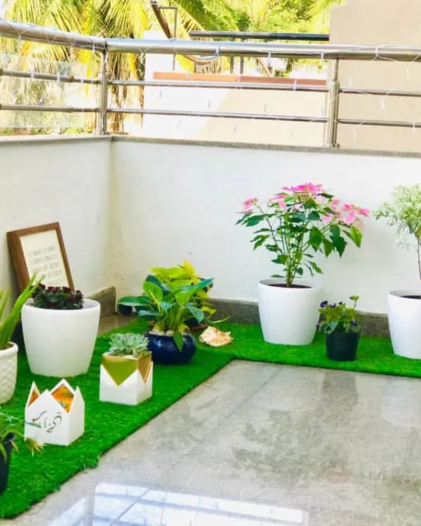 A full view of the balcony makeover for my client Spoorti. I combined a variety of plants in different white and decorative pots, arranged on artificial grass mats, to create a complete and cohesive garden space that feels both clean and vibrant.