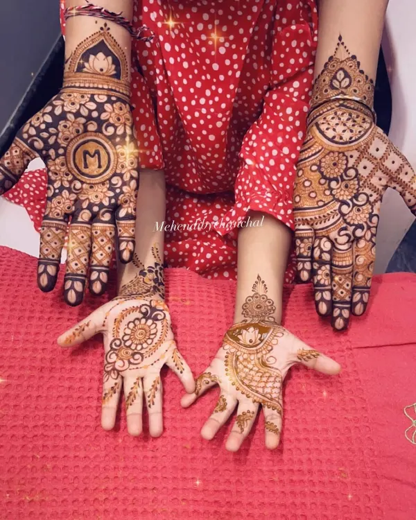 A happy family mehendi moment! This picture shows a beautiful design for the mom and a cute, simple mandala for her little one.