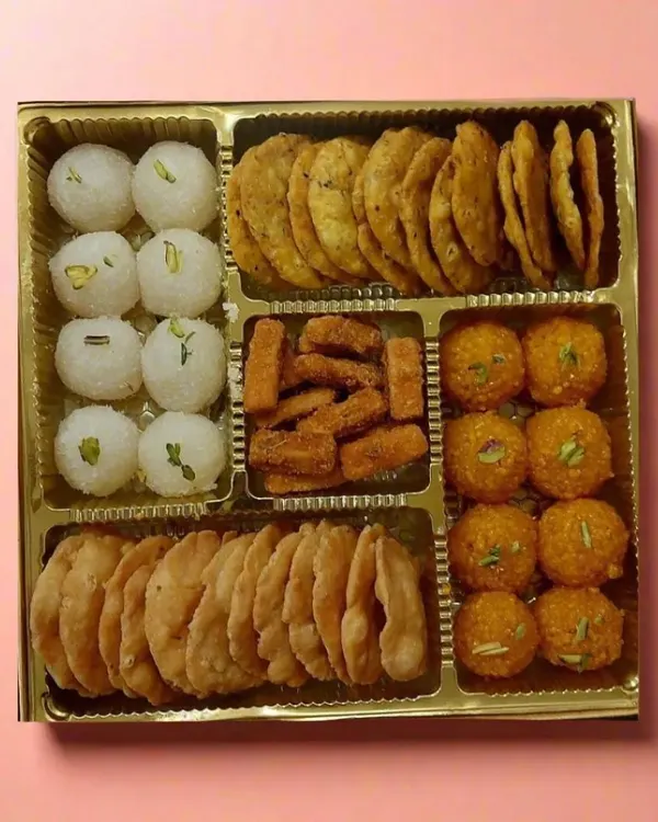 A glimpse into our special assorted box, perfect for any celebration. It features a mix of our signature sweets like coconut and motichoor laddoos, alongside savory mathri and shakarpara, offering a complete taste experience in one beautiful package.