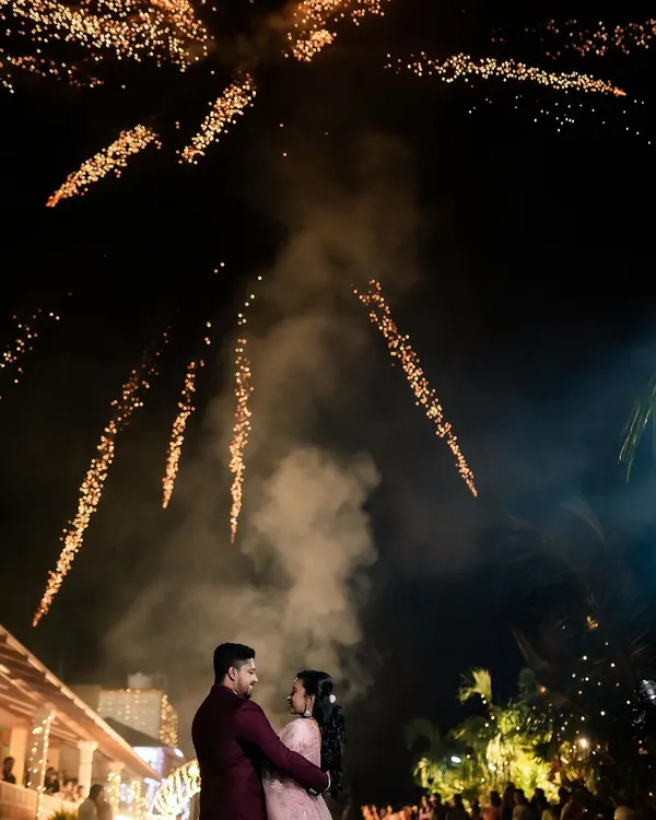 A magical reception photo of the couple under a sky full of fireworks. We specialize in capturing these spectacular, once-in-a-lifetime moments.