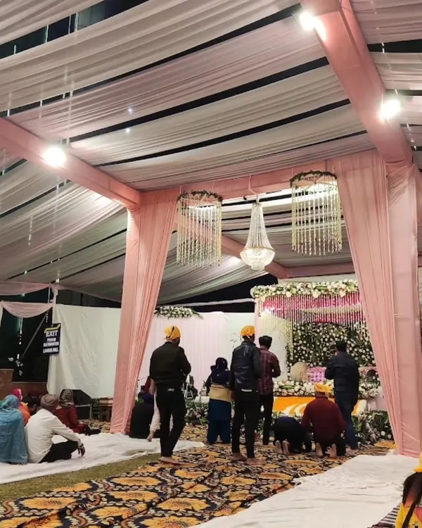 A wide view of the Anand Karaj setup, showing the seating arrangement for the guests and the beautifully decorated space for the Guru Granth Sahib.