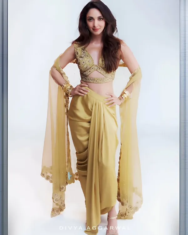 The radiant Kiara Advani looking effortlessly chic in the golden Lydia Cape Set. The modern dhoti-drape skirt and embellished blouse create a perfect fusion look.