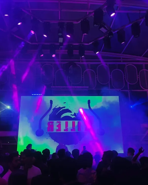 The club is washed in purple light as the beat drops. The right lighting and haze create an atmosphere where people can lose themselves in the music.