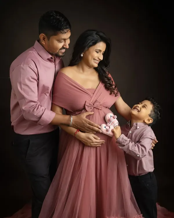 The big brother is ready for his new role. Having him hold the tiny baby shoes to the bump is such an adorable way to capture his excitement for the new arrival.