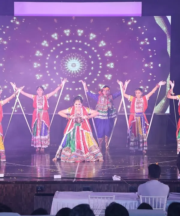 A beautiful formation from one of our stage Garba performances. The dancers use dandiya sticks to create a symmetrical and visually striking pattern, all while wearing colorful traditional attire.