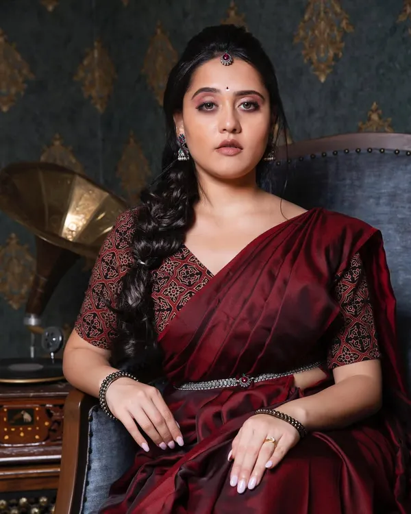 A royal and majestic look for actress Vedangi Kulkarni. This styled shoot features a deep maroon saree, a braided hairstyle, and bold, expressive makeup.