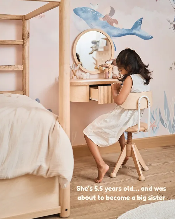 We decided to redo my daughter's wallpaper to prepare her for becoming a big sister. This is her at her new dresser, a space designed just for her.