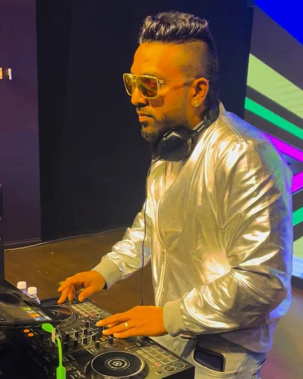 Focused on the mix during a corporate gig. I'm using the Pioneer controller to line up the next track, ensuring a seamless flow of music throughout the night.