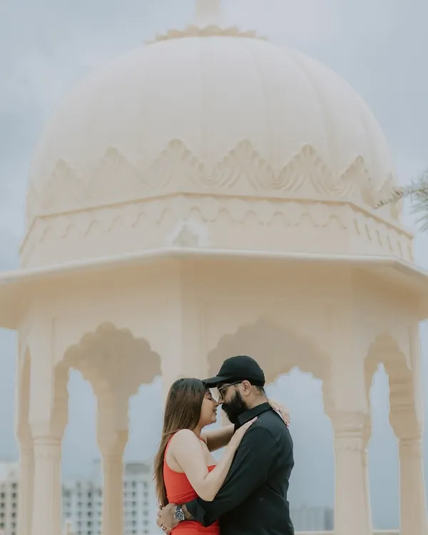 An intimate moment shared under the dome of a beautiful palace structure, creating a classic and romantic silhouette.