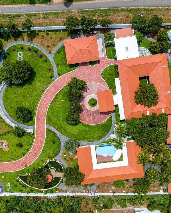 An aerial masterplan view of our Greenfield farmhouse project. The layout was meticulously planned to include a winding driveway, distinct zones for living and leisure, and lush landscaping that envelops the entire property.