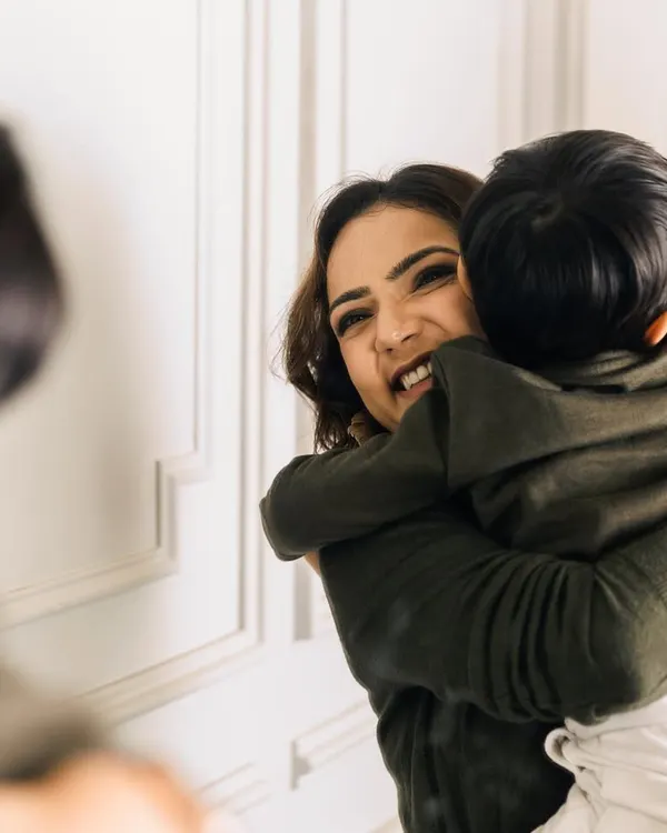 A warm embrace from your child is like holding your entire world in your arms. This candid moment, reflected in the mirror, adds a layer of intimacy and tells a story of pure, unconditional love.