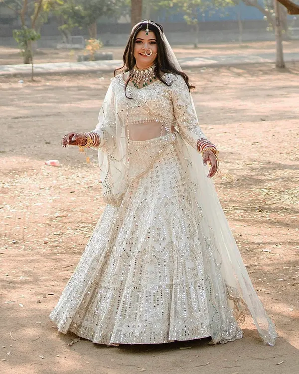 She dreamed of an ivory lehenga with full mirror and gotta pati work, and we brought it to life. This outfit is for the bride who wants to shine with timeless elegance on her wedding day.