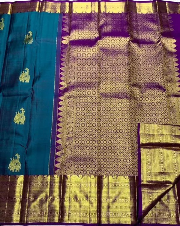 A closer look at the rich texture of the handwoven Kanchipuram silk saree, showcasing the pure 2g zari work on the border and pallu.