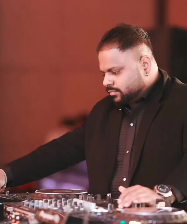 Focused on the mix during a lively wedding event. Dressed for the occasion, I'm at my Pioneer console, ensuring every track flows seamlessly to keep the celebration going.