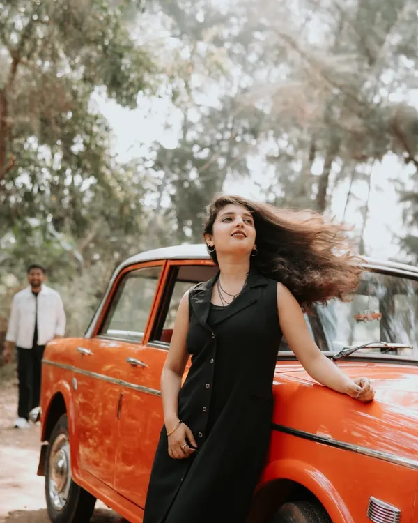 A cinematic portrait of the bride-to-be leaning against a vintage car, her hair caught in the wind. This shot has a cool, free-spirited vibe that I love to capture.