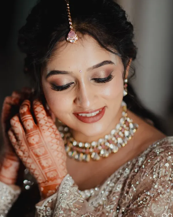 A close-up of a soft glam reception look. I used warm, shimmery eyeshadows and a neutral pink lipstick to create a romantic and modern feel that enhances her natural features without feeling heavy.