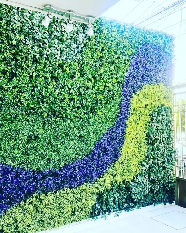 This is a large outdoor green wall I installed, using different shades and textures of artificial foliage to create a wave-like pattern. This custom design work is perfect for balconies, terraces, or building exteriors.