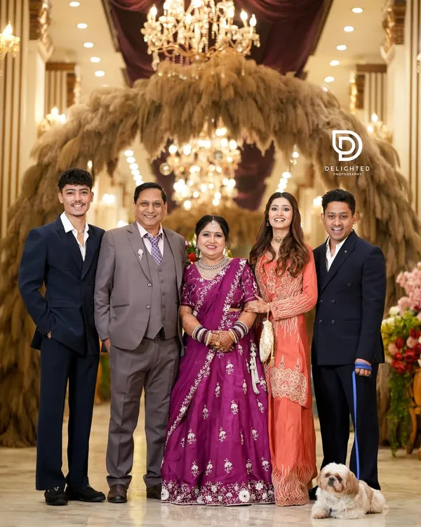 A beautiful family portrait taken at a 25th-anniversary celebration. It captures three generations and even the family pet, all gathered to honor the happy couple.