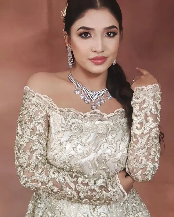 This elegant off-the-shoulder gown is paired with a stunning, multi-layered American Diamond necklace and matching earrings. This is a perfect look for a glamorous reception or engagement party.