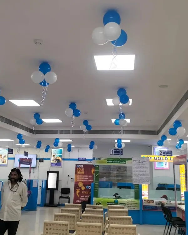 Simple and effective blue and white balloon clusters hanging from the ceiling of a corporate office. This is an easy way to decorate a large office floor for a company-wide celebration.