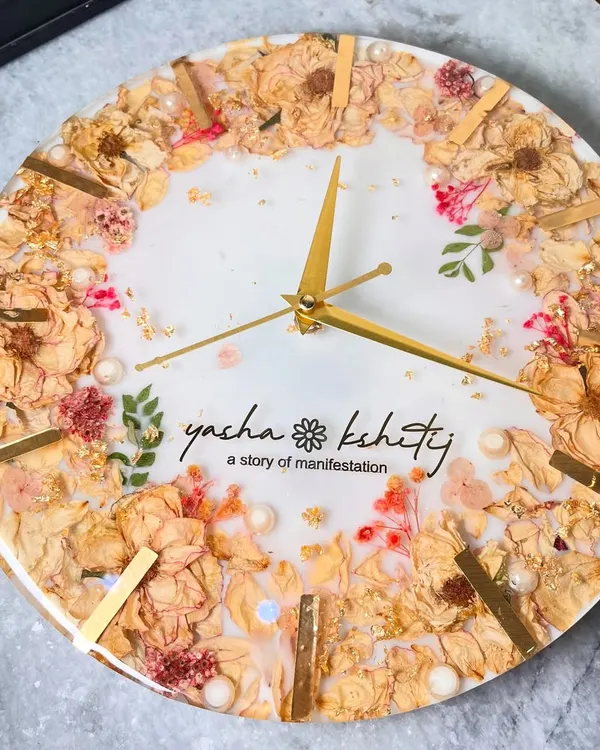 This 12-inch wall clock is a beautiful way to preserve your varmala. I arranged the couple's wedding flowers around the edge, with their names and a personal tagline, 'a story of manifestation', in the center.