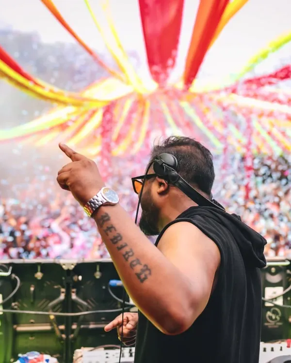 Pointing to the sky as the confetti falls at a massive Holi event. My goal is to command the stage and direct the energy of thousands, making sure every single person is part of the celebration.