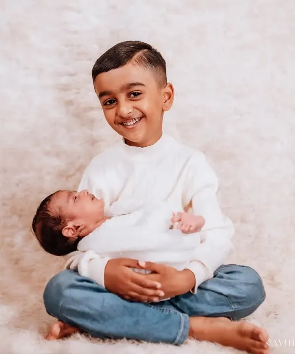 The proudest big brother. His joyful smile as he holds his new sibling says everything. These are the moments that become treasured family memories.