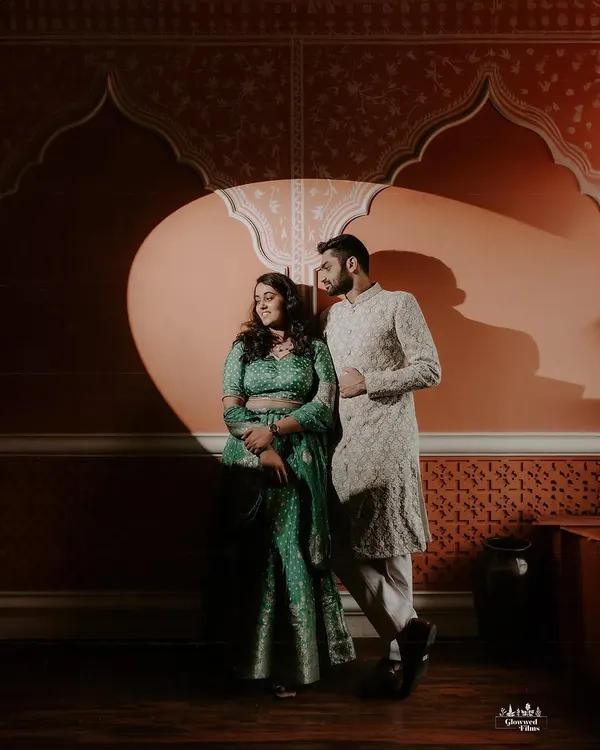 In the studio, we play with light and shadow to create dramatic, artistic portraits. This image uses a single spotlight to highlight the couple against a richly textured, Rajasthani-inspired backdrop, showcasing our versatility in a controlled creative environment.