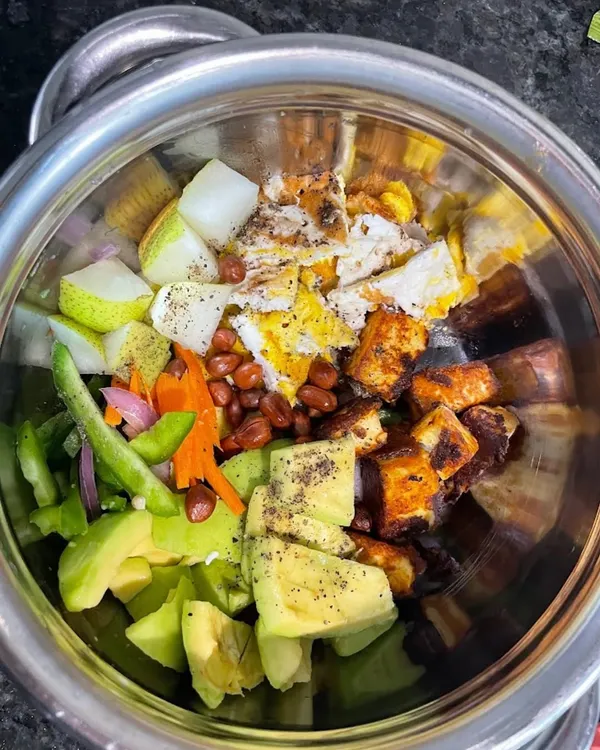 A client's vibrant and protein-packed salad bowl with paneer, avocado, peanuts, and fresh vegetables, tailored for their specific nutritional needs.