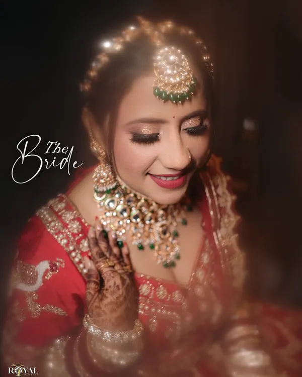 A beautiful close-up of the bride, capturing her happy smile and the intricate details of her makeup and jewelry.