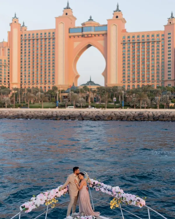 A breathtaking pre-wedding portrait on a private yacht, with the iconic Atlantis, The Palm in Dubai creating a majestic backdrop. This is the pinnacle of luxury destination photography, blending opulence with intimate romance.