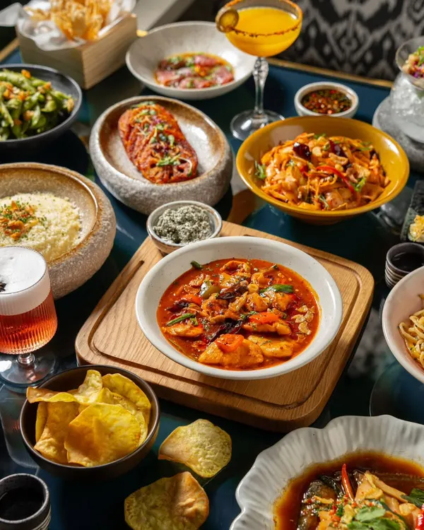 A full table spread showcasing the variety of an Asian-inspired menu. This type of large-scale food photography is perfect for website banners and promotional materials.