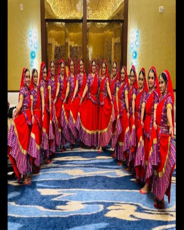A large dance troupe dressed in our matching red Ghoomar costumes. This image is a perfect example of our ability to supply uniform, high-quality outfits for large-scale stage performances.