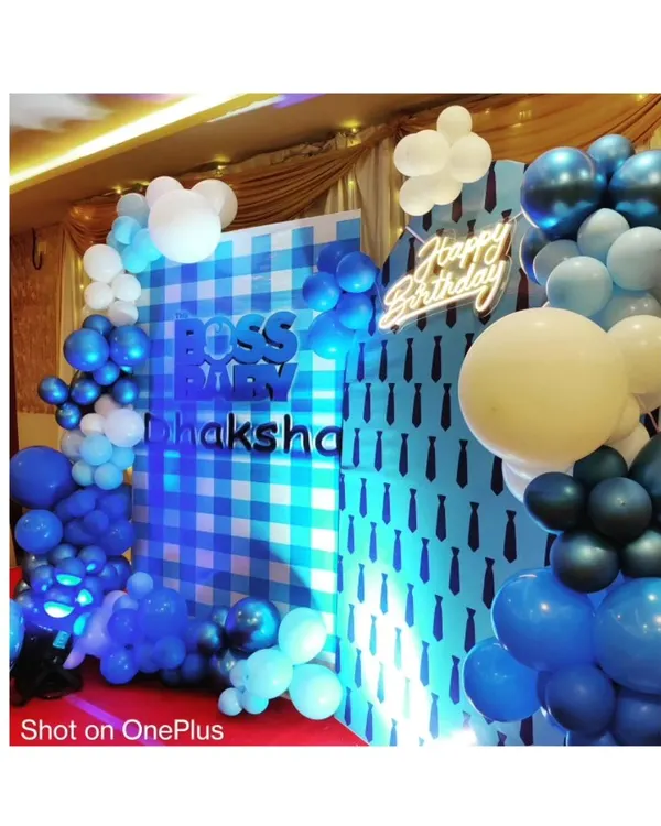 We bring popular kids' themes to life, like this complete 'Boss Baby' birthday party setup. This includes a custom-printed backdrop, a vibrant balloon arch in shades of blue and white, and marquee letters spelling out the birthday boy's name.