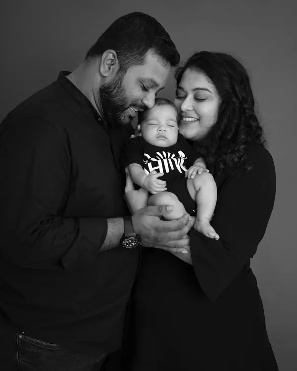 A quiet, intimate moment between new parents and their sleeping baby. This black and white newborn portrait focuses on their loving expressions and the peacefulness of their new life together.