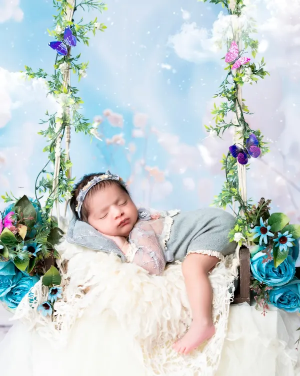 A newborn portrait capturing the pure serenity of early life, styled in a dreamy, floral swing setup to create a truly magical memory. This is the art of newborn photography, focusing on peaceful and beautiful moments.