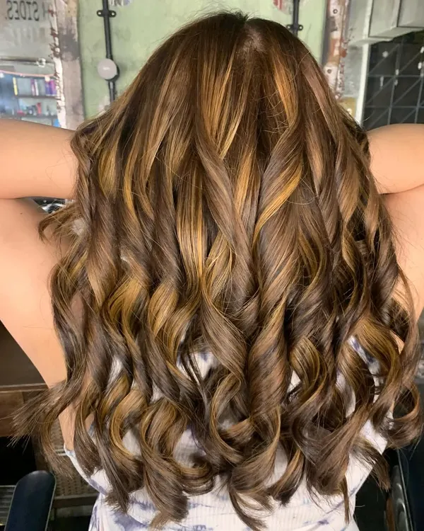 A stunning color correction. This client had a lot of previous dark color build-up, and we transformed it into this beautiful, sun-kissed look using a bleach and tone technique.